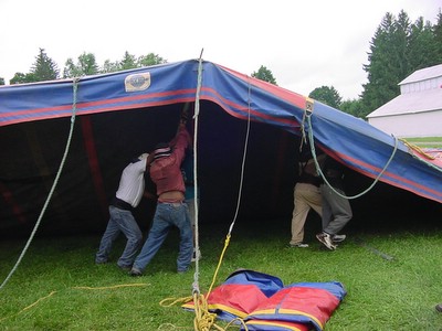 men raising sides of the bigtop